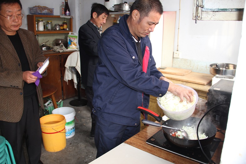 “帮扶五人组”成员帮“老闷”做饭.JPG